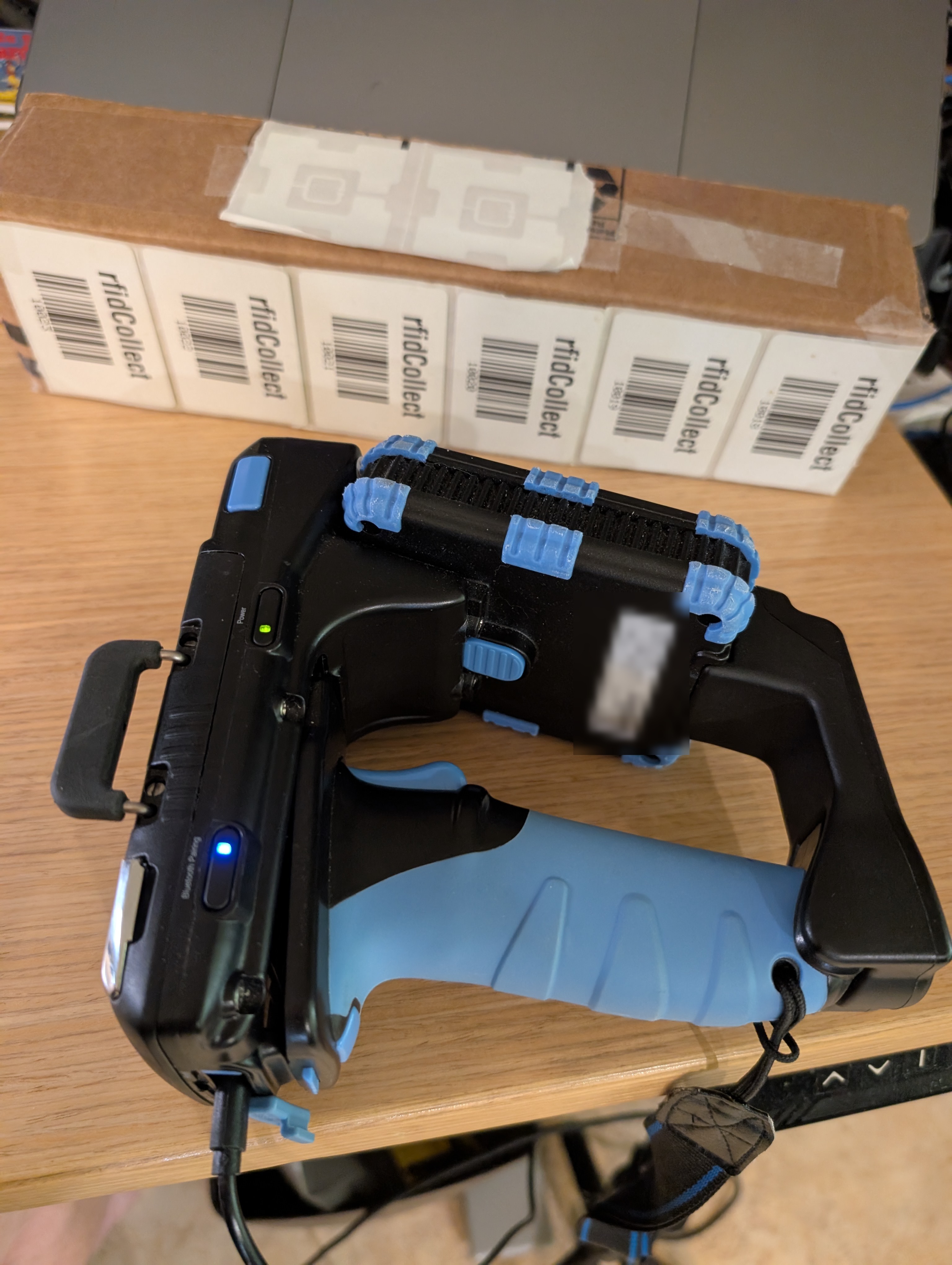 The capture bench: a CS108 handheld in a printed cradle, aimed at the tagged box
